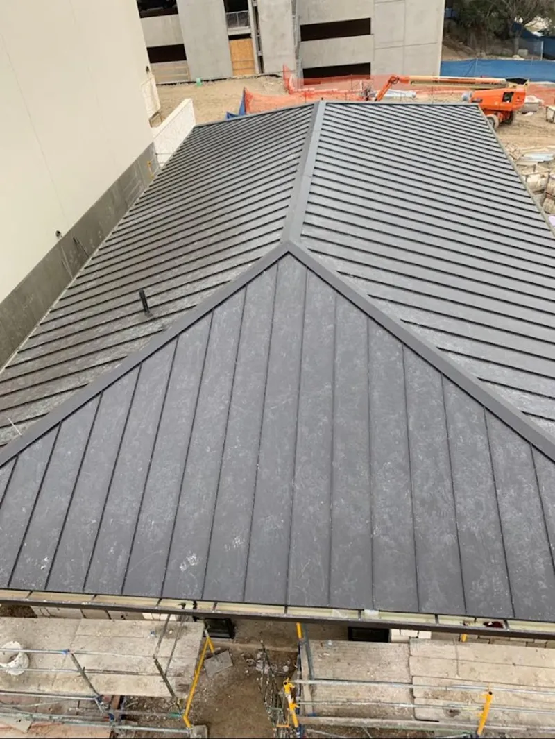 Commercial metal roof construction with crane equipment in Jersey Village